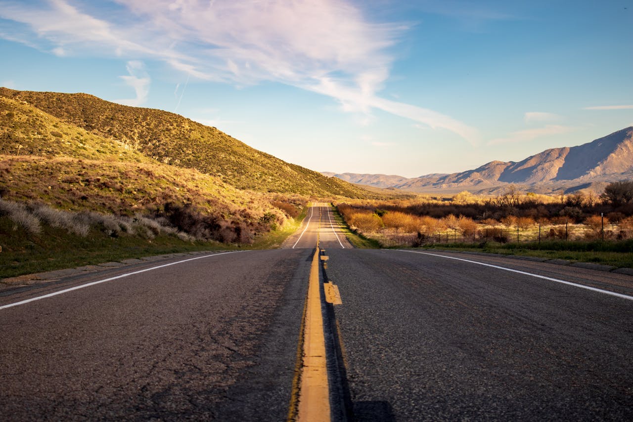 A scenic highway cutting through mountain landscape under a clear sky, perfect for travel and exploration.